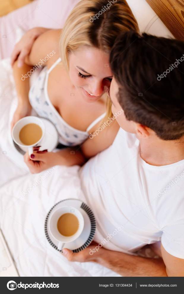 Couple drinking coffee in bed